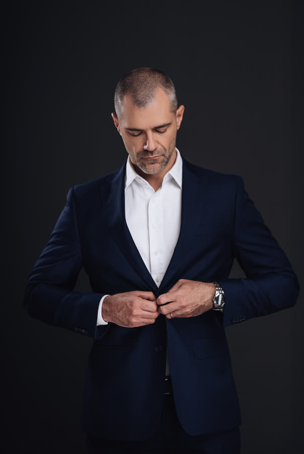 Roberto Monfort abotoando o paletó, retrato de estúdio