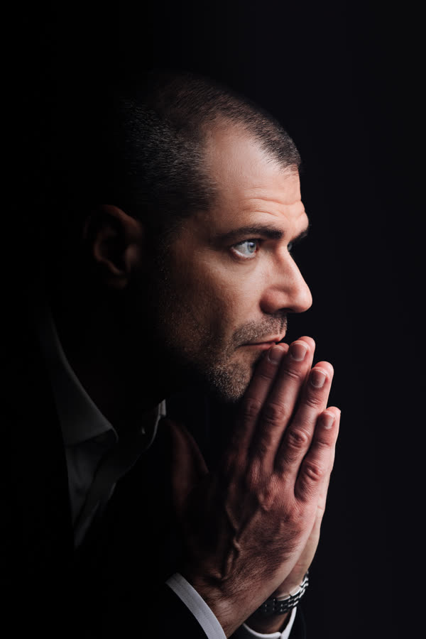 Roberto Monfort de lado, em close, mão no queixo, pensativo